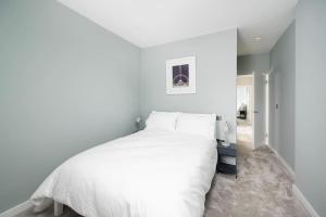 伦敦Oak Tree Lodge的卧室设有一张白色大床和一个走廊