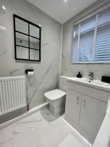 锡厄姆Coastal Apartments No 1的白色的浴室设有卫生间和水槽。