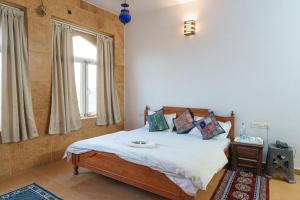 斋沙默尔Wonbin Safari Jaisalmer的一间卧室设有一张床和一个窗口