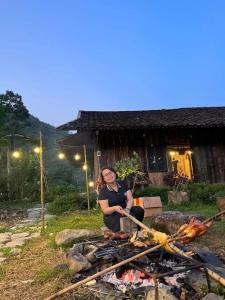 Nà GiảoLũng Mười Homestay的坐在火前的女人