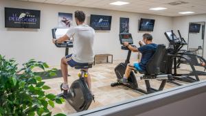 拉罗克加雅克佩里戈尔酒店的两名男子在健身房骑健身自行车