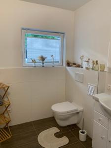 博登斯多夫Ferienwohnung KaRo的白色的浴室设有卫生间和窗户。