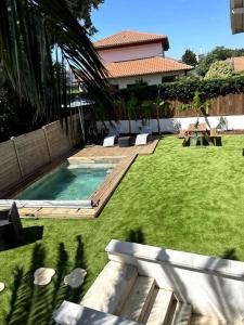 比亚里茨Logement avec piscine privée chauffée的一个带游泳池和房子的后院
