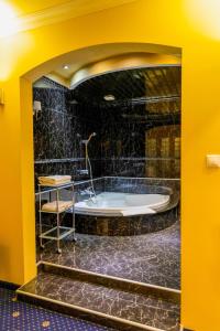 普里什蒂纳Hotel Ambasador Prishtina的浴缸位于一个黄色墙壁的房间