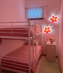 卡什塔涅拉德佩拉Sweet Home - Praia das Rocas的粉红色的卧室配有两张双层床和梳妆台