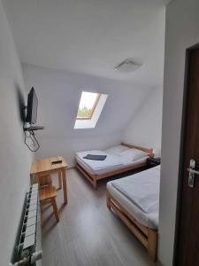 斯罗姆韦斯尼Willa Gazda的一间卧室设有两张床、一张桌子和一个窗口