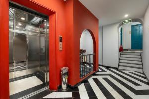 河内河内旧城景旅舍的走廊上设有红色的门,铺有瓷砖地板
