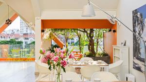 胡志明市LAKEVIEW Park Villa - Private Pool, BBQ, Karaoke的用餐室配有粉红色鲜花桌