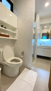 清莱Cozy place @ Chiangrai的白色的浴室设有卫生间和淋浴。