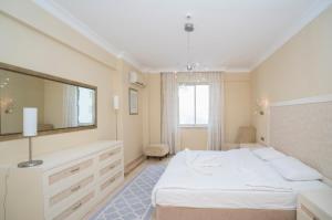 阿拉尼亚ALANYA GOLD CİTY的卧室配有白色的床和大镜子