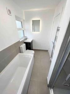 邓格洛The Chalet的白色的浴室设有浴缸和卫生间。