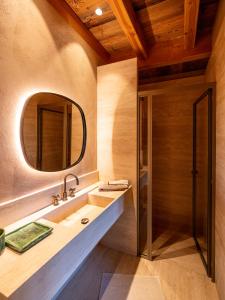 巴斯洛内特Superbe ferme rénovée en chalet de luxe en PLEINE NATURE的一间带水槽和镜子的浴室