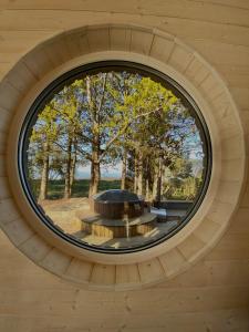 KalniHoliday House "Sea Nest"的木制建筑中的圆窗,设有圆桌