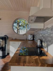 KalniHoliday House "Sea Nest"的厨房配有木制台面和窗户