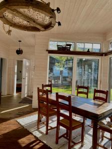 KalniHoliday House "Sea Nest"的一间带木桌和椅子的用餐室