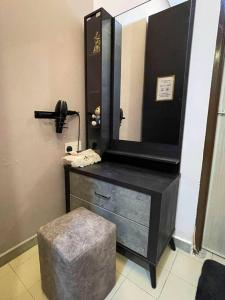 甘文丁Cozy Stay At Raintown Taiping的浴室设有梳妆台、镜子和凳子