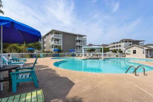 大西洋滩Atlantic Beach Resort, a Ramada by Wyndham的一个带椅子和蓝伞的游泳池