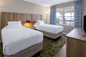 大西洋滩Atlantic Beach Resort, a Ramada by Wyndham的酒店客房设有两张床和窗户。