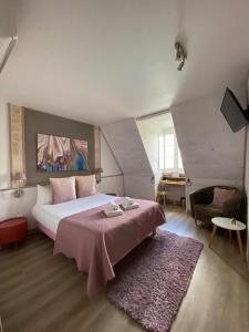 马尔凯Hôtel Bien-Être Aux Cyprès de Marquay的一间卧室配有一张带粉色毯子的大床