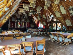 莫伊西德约斯Pensiunea La Mogan的用餐室设有桌椅和木制天花板