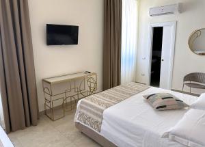 那不勒斯Residenza d’epoca Chiostro San Francesco的卧室配有一张床,墙上配有电视