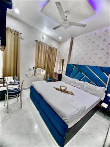 阿姆利则Swaran hotel的一间卧室设有一张床铺、一张桌子和天花板