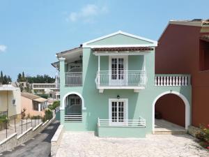 达西亚Spiros Athinaios Apartment's的蓝色房子,在街上设有白色阳台