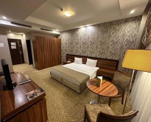 埃尔比勒Jouhayna Hotel&Suite的配有一张床和一张书桌的酒店客房
