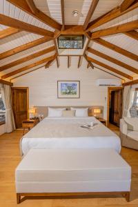 达特恰Kairos Valley Health & Nature Resort的卧室设有白色大床和木制天花板。