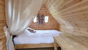 GivrauvalLes Cabanes Flottantes的小木屋内的卧室,配有一张床和一张桌子