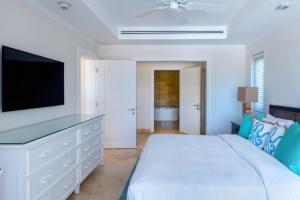 圣菲利普白鹤度假村的白色卧室配有床和平面电视
