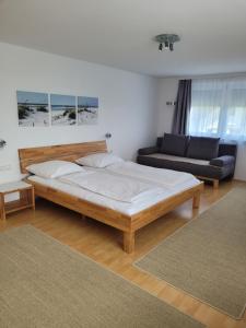 赫尔布兰茨Gästezimmer Suppan的一间卧室配有一张大床和一张沙发