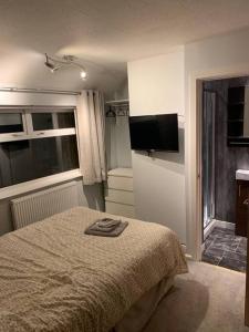 卢顿Superb 4 Bed 4 Bath House Right by Luton Airport的一间卧室配有一张床和一台平面电视