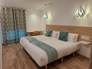 毕尔巴鄂奥特泰克斯酒店的卧室配有带绿色枕头的大型白色床