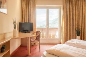 梅拉诺伊丽莎白酒店的酒店客房设有一张书桌、一台电视和一个窗户。