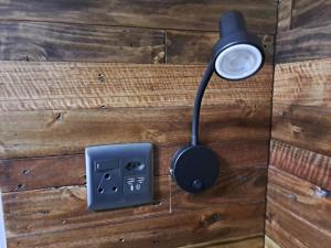 布隆方丹Mossie Nes - Self Catering的木墙上的灯,带插座