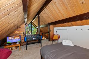 大熊湖New!!! Dreamy Bear Haus- Updated Retro Retreat & Spa, Pet & Kid Friendly的阁楼上设有一间卧室,配有一张床和一台电视