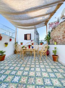 丹吉尔Casa al Captane au Medina Tanger的铺有瓷砖地板,设有带桌椅的天井。
