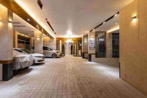 达卡Gulshan Stylish 3 bedroom Luxury Apartment in Prime location的走廊上有两个汽车停在大楼里