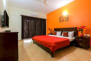 巴加Royale Holiday Villa - 4BHK, Baga的一间卧室配有一张带橙色墙壁的大床