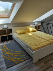 艾斯特根Gemini Apartman的一间卧室配有一张带黄色床单的床和一扇窗户。