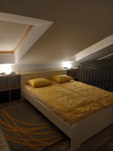 艾斯特根Gemini Apartman的一间卧室配有一张带两个黄色枕头的床