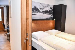 克尼格利斯滕Astn Hütten - Königsleiten - Ferienwohnungen的卧室配有一张床铺,墙上配有电视