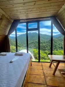 巴统Mtirala Skhivi Cottage的一张位于带大窗户的房间内的床铺