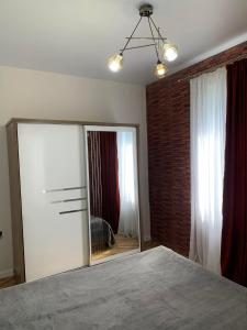 姆兹瓦内康茨基Guesthouse Mtsvane Koncxi 22的一间卧室设有大镜子和砖墙