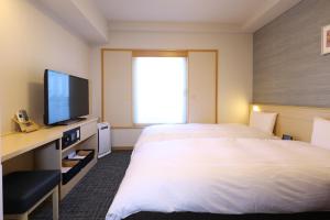 东京Dormy Inn Premium Ginza的酒店客房设有一张大床和一台电视。