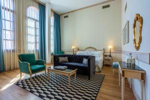 托莱多欧仁妮德蒙蒂若傲途格精选酒店的酒店客房配有一张床、一张沙发和椅子。