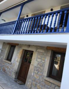 拉斯特雷斯Tela Marinera的一间设有蓝色阳台和两扇门的房子