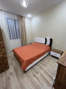 巴统MT House的一间卧室配有一张带橙色床罩的床