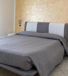 托尔博莱Appartamenti Nataly的一间卧室配有一张大床和灰色的被子